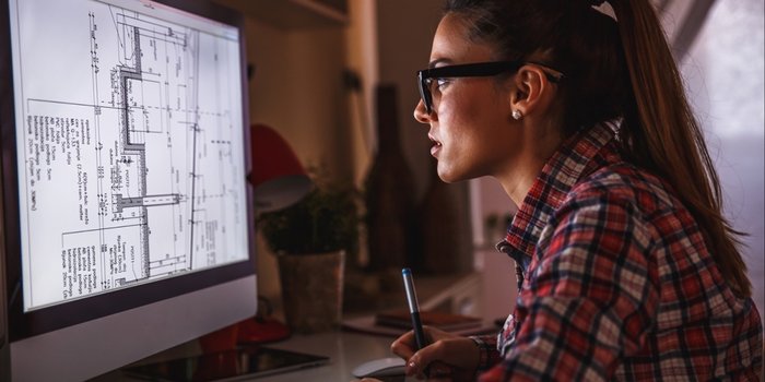 Woman working at a computer on technical drawings — representing women in technology